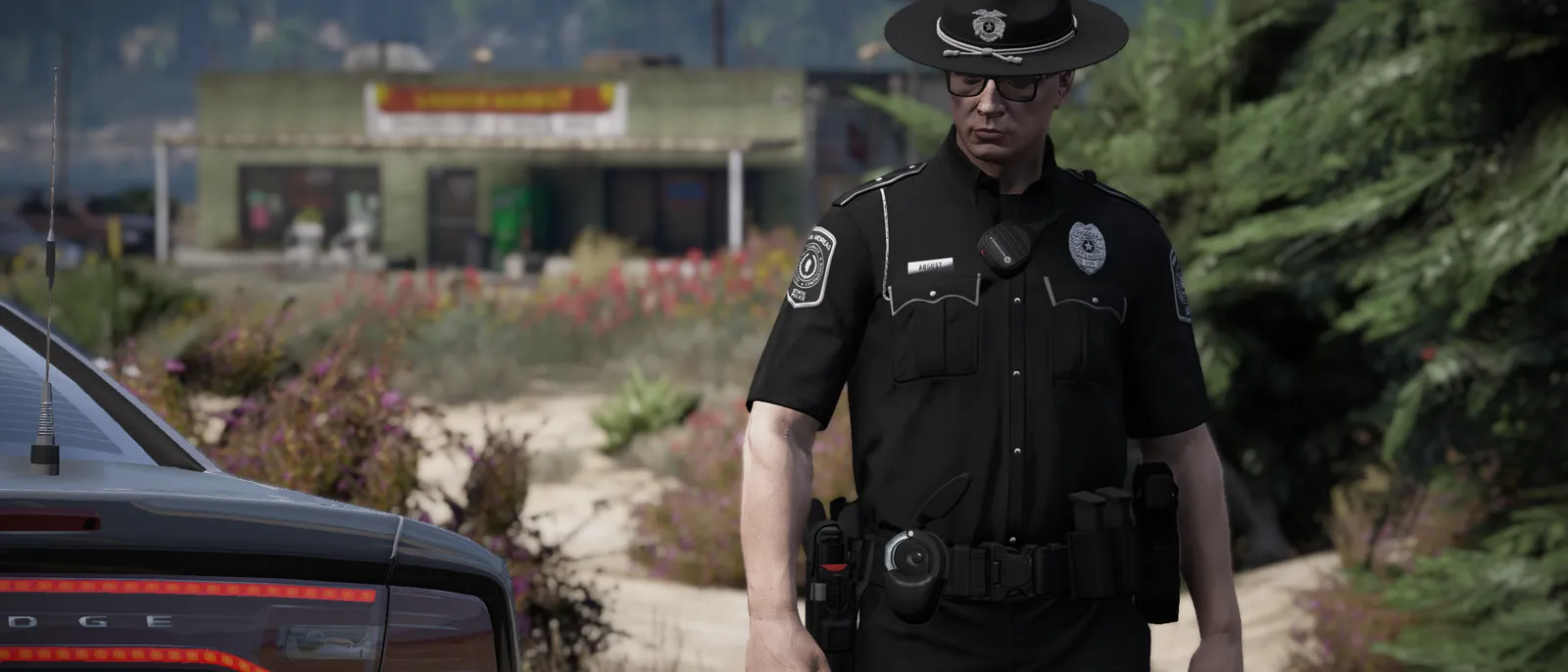 A state trooper standing beside a patrol car